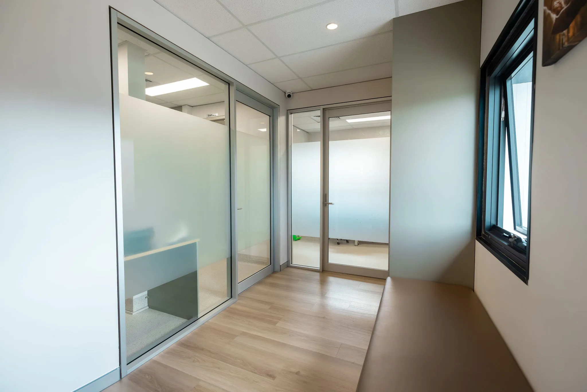 clinic hallway at austral podiatry with frosted glass office doors and seating bench podiatry clinic in austral, nsw